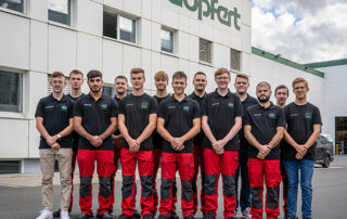 Gruppenfoto der 14 Auszubildenden vor der Produktionshalle mit Göpfert Schriftzug im Hintergrund