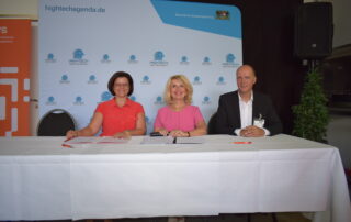 Frau Esther Göpfert bei der Vertragsunterzeichnung zusammen mit Landrätin Tamara Bischof und Robert Gräfner (Präsidenten der THWS) an einem Tisch